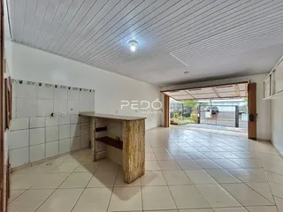 Interior de uma sala com piso de cerâmica e parede de azulejos brancos.