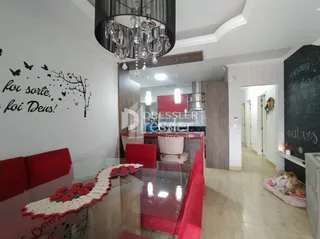 Sala de estar com decoração vermelha e mesa de vidro.