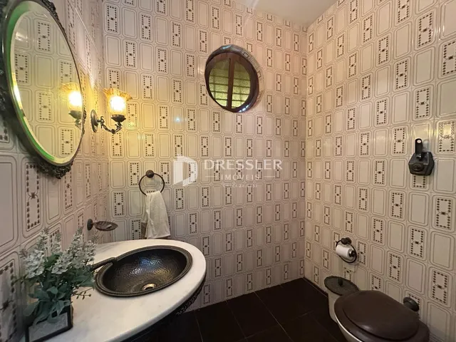 Foto de um banheiro com revestimento de azulejos brancos.