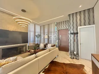 Sala de estar moderna com lareira e grandes janelas em Lajeado.