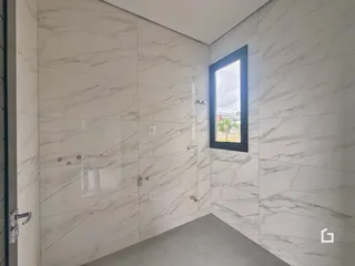 Vista interna de um corredor com paredes revestidas de mármore branco.