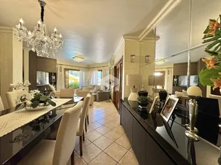 Interior de uma sala de estar com decoração clássica e espelhos grandes.