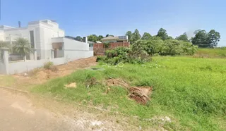 Vista da fachada de uma residência em Lajeado, Brasil, com um terreno gramado à frente.