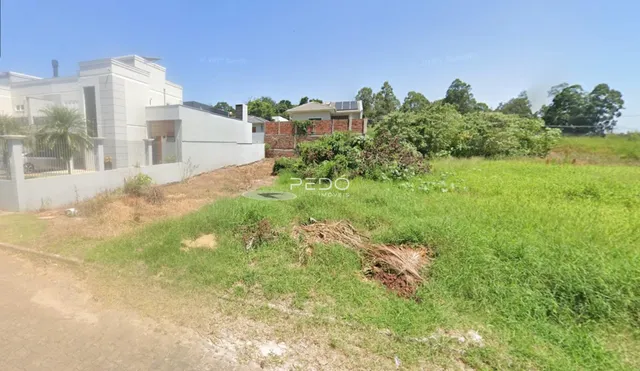 Vista da fachada de uma residência em Lajeado, Brasil, com um terreno gramado à frente.