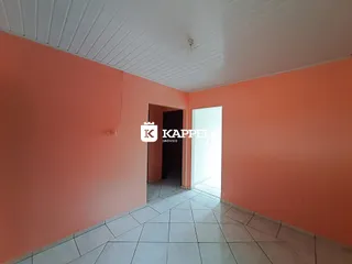 Hallway com paredes cor de salmão e piso de cerâmica clara.
