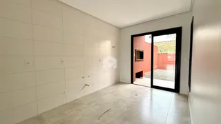 Corredor interno com paredes brancas e piso de concreto.