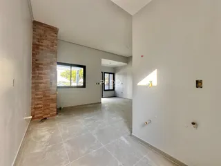 Espaço interno amplo com parede de tijolos aparentes em uma residência.