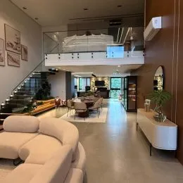 Ambiente interno com pé direito alto e escadaria visível em um apartamento.