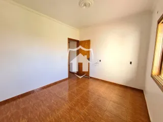 Vista interna de um corredor com piso de cerâmica marrom.