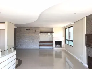Sala de estar com piso claro e parede de tijolos expostos em um imóvel.