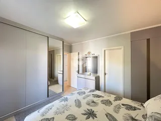 Foto de um quarto com armários grandes e uma cama no interior de uma residência.