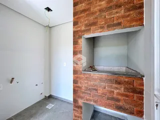 Parede interna com tijolos aparentes e nicho em um imóvel.