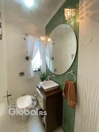 Foto de um banheiro interno com azulejos verdes e espelho.
