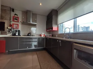 Vista da cozinha moderna com armários cinzas e janela grande.