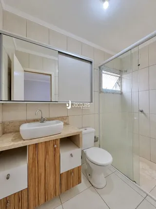 Foto de um banheiro com bancada e box de vidro em um imóvel no Brasil.