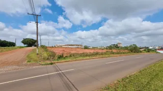 Vista de uma estrada rural com céu azul e nuvens.