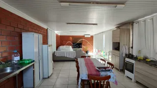 Sala de estar com sofá e mesa de jantar em um ambiente com parede de tijolos aparentes.
