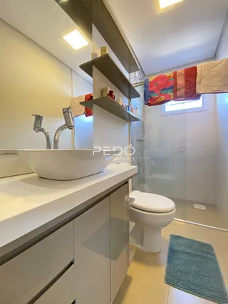 Foto do interior de um banheiro moderno com bancada branca.