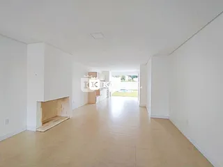 Hall de entrada com piso claro e lareira visível.