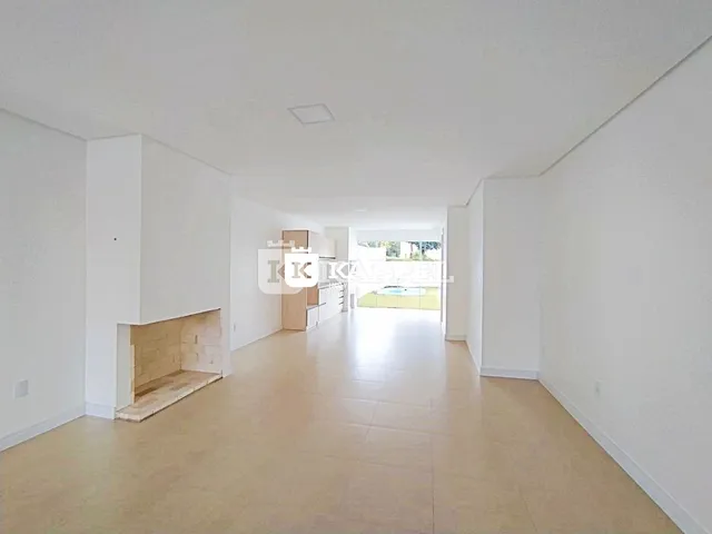 Hall de entrada com piso claro e lareira visível.