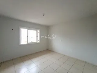 Uma sala de estar com paredes brancas e piso de cerâmica clara.
