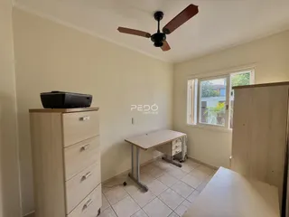 Quarto interno com armário e mesa de trabalho em um ambiente claro.