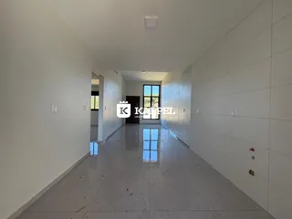 Corredor longo e claro com piso reflexivo que leva a outra área da residência.
