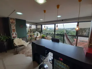 Sala de estar com vista para a paisagem externa através de grandes janelas.