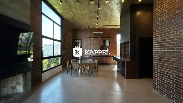 Sala de estar com grandes janelas e piso de concreto aparente.