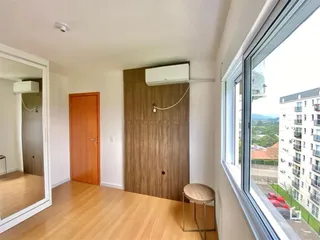 Interior de um ambiente com piso de madeira e porta de madeira.