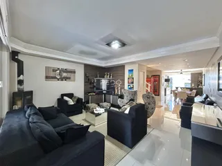 Sala de estar moderna com sofá e poltronas em um apartamento em Lajeado.