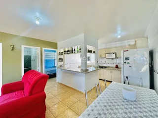 Sala de estar com decoração e cozinha em um imóvel no Brasil.