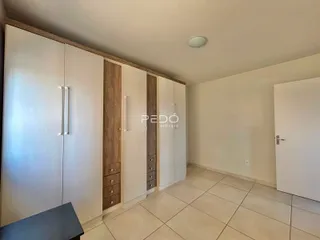 Interior de um ambiente com armários embutidos e piso de cerâmica clara.