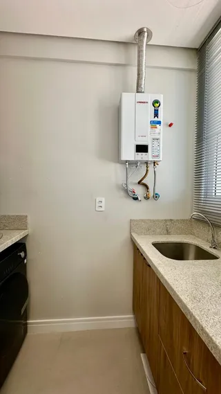 Vista de uma cozinha com armários de madeira e bancada clara.