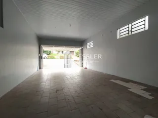 Interior de uma sala com piso de cerâmica e uma abertura para o exterior.