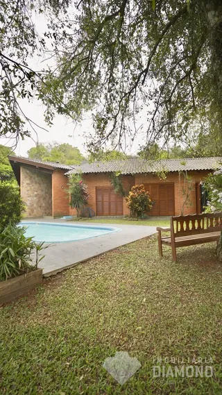 Foto da fachada de uma casa com piscina e jardim em Lajeado.