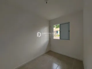 Vista interna de um cômodo com paredes brancas e piso de cerâmica.