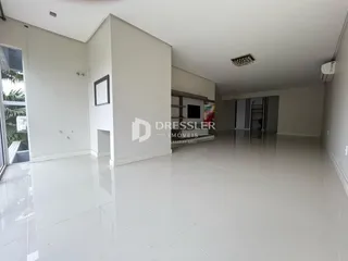 Ambiente interno de uma sala ampla com piso de cerâmica clara.