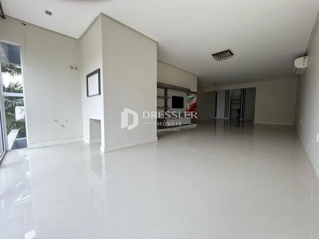 Ambiente interno de uma sala ampla com piso de cerâmica clara.