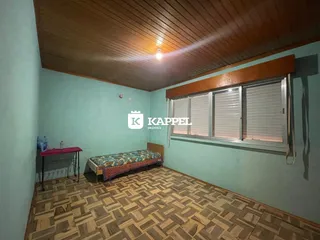 Quarto com cama e piso de madeira em um apartamento.