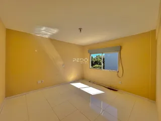 Ambiente interno de uma sala com piso de cerâmica e paredes amarelas.