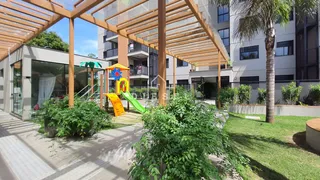 Vista externa de um pátio com playground e vegetação em Lajeado.