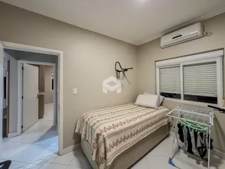Quarto com cama e janela em ambiente claro.
