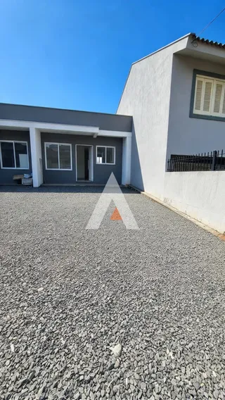 Fachada da casa em Lajeado, Brasil, com área de cascalho no primeiro plano.