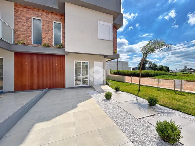 Fachada de uma residência moderna em Lajeado, Brasil, com área externa pavimentada.