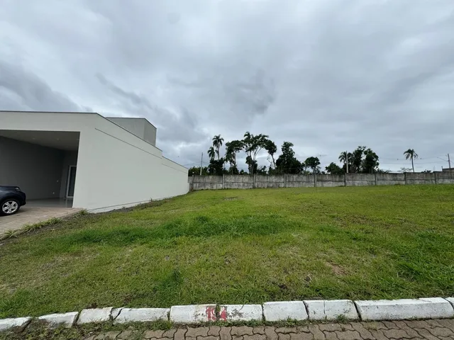 Fachada de uma residência moderna com gramado e cerca.