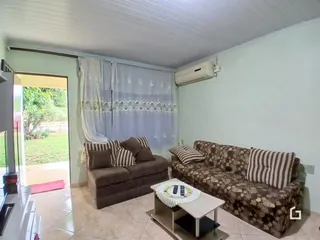 Sala de estar com sofá e vista para o jardim.