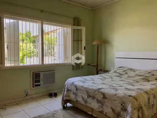 Quarto com paredes verdes e grandes janelas.