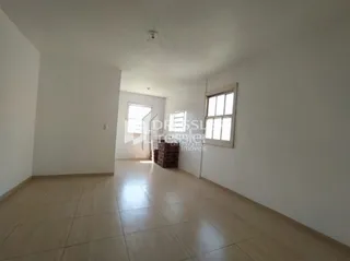 Hall de entrada com piso de madeira clara e paredes brancas.