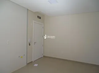 Hall de entrada com porta branca em um imóvel.